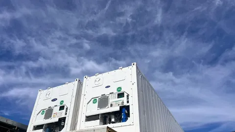 Contenedores Reefer blancos contra el cielo en patio de depósito